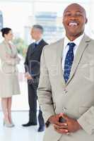 Young businessman laughing while standing upright with his hands