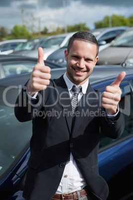Businessman raising his thumbs while smiling