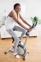 Black woman doing exercise bike with headphones