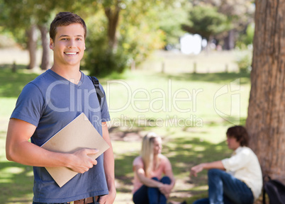 Portrait of a smiling student holding a textbook