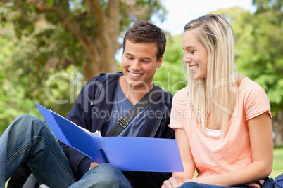 Close-up of a smiling tutor helping a teenager to revise