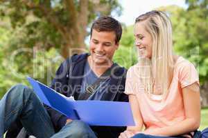 Close-up of a smiling tutor helping a teenager to revise