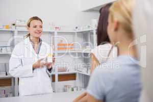 Smiling pharmacist holding on her hands a box