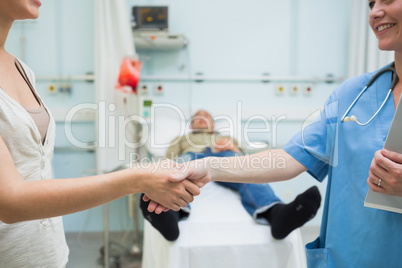 Nurse shaking hand of a patient