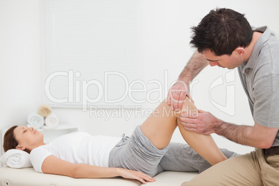 Brown-haired man massaging the knee of a woman