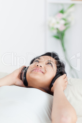 Woman lying on a sofa with headphones on