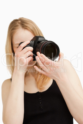 Young woman aiming with a camera