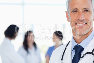 Smiling doctor with his medical interns behind him