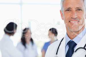 Smiling doctor with his medical interns behind him