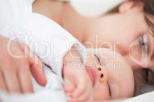Woman and her baby lying side by side