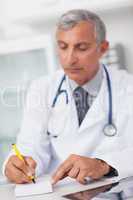 Doctor writing on a notepad at his desk