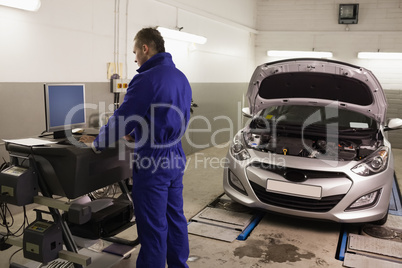 Mechanic looking at a computer while standing