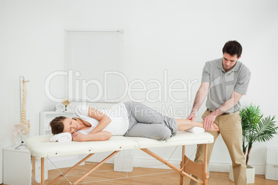 Woman lying on her side while being massaged by a man