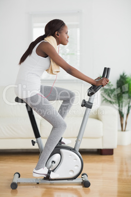 Side view of a black woman doing exercise bike