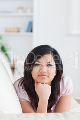 Woman relaxing on a couch holding her head with her fist