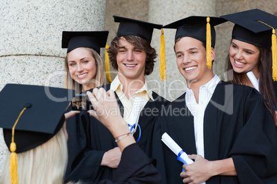 Close-up of a graduate taking a picture of her friend