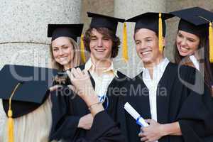 Close-up of a graduate taking a picture of her friend