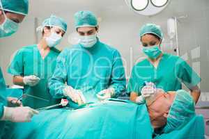 Surgical team performing on a patient belly