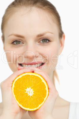 Close up of a woman squeezing an orange between her hands