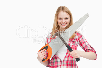 Woman holding a hammer and a saw