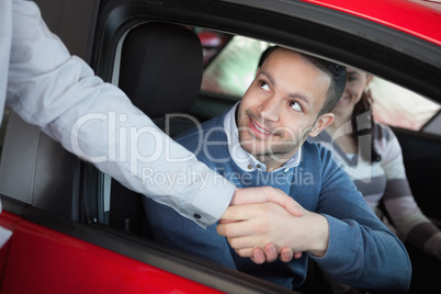 Man shaking the hand of a car dealer