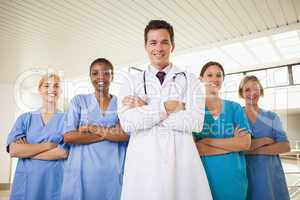 Smiling doctor and nurses with arms crossed