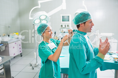 Nurse attaching the surgical uniform of a surgeon