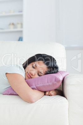 Woman resting on a couch with her head on a pillow