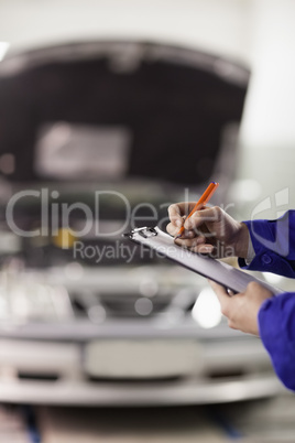 Focus on a man writing on a clipboard