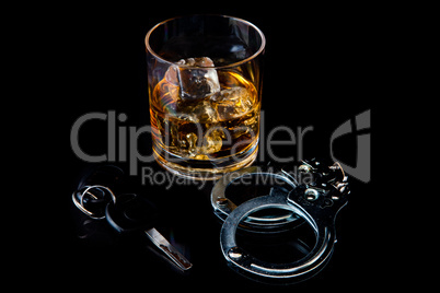 Whiskey on the rocks with handcuff and car key