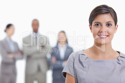 Big close-up of a businesswoman smiling and a team in background