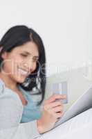 Woman looking at a tactile tablet while holding a credit card