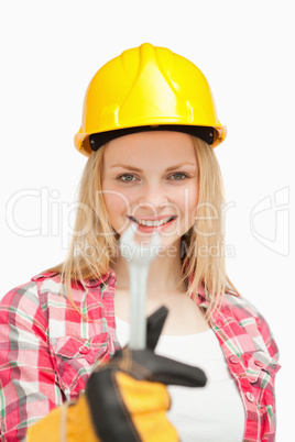 Smiling woman presenting a wrench