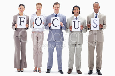 Happy business team holding the letters of FOCUS