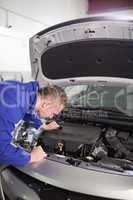 Mechanic looking inside an engine of car