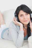 Woman wearing headphones and laying on a couch