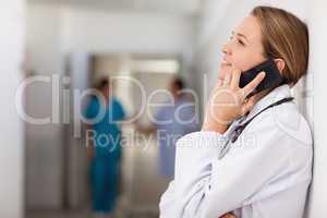 Doctor against a wall phoning