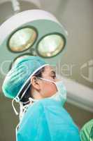 Woman surgeon under a surgical light