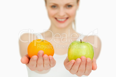 Young woman presenting fruits while smiling