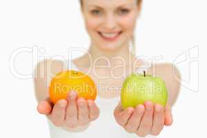 Young woman presenting fruits while smiling