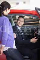 Man sitting in a car while talking to a woman