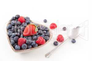 Berries in  a heart shaped bowl with spoon