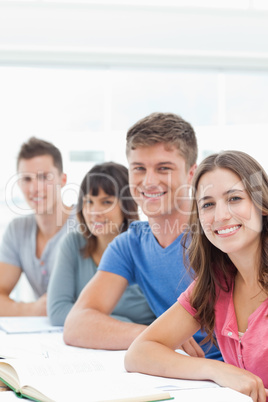 A group looking in front of them into the camera as they smile