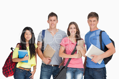 Students looking at the camera as they hold notepads