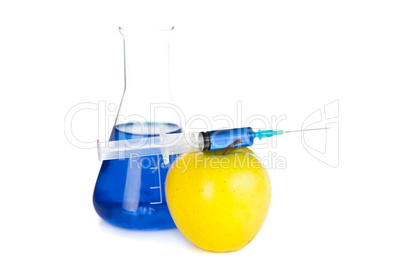 Syringe on an apple next to a beaker
