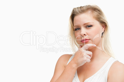 Serious blonde woman placing her hand on her chin