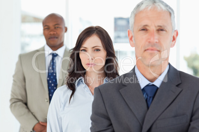 Young businesswoman standing upright between a colleague and her