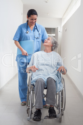 Elderly patient in a wheelchair looking at a nurse