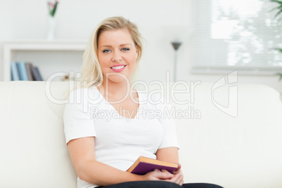 Woman sitting on a sofa with a book