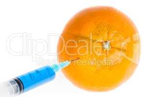 Syringe injecting in an orange